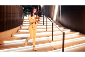mujer bajando por unas escaleras decoradas con lámparas LED empotrables en piso