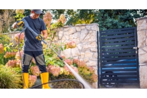 hombre trabajando en un jardín con una desbrozadora